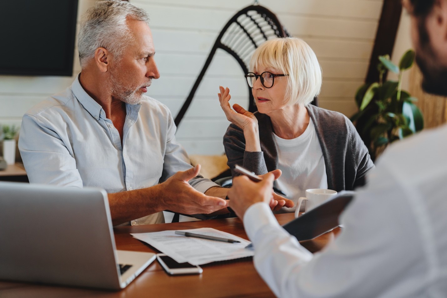 Retiring couple discussing estate planning options with a financial advisor